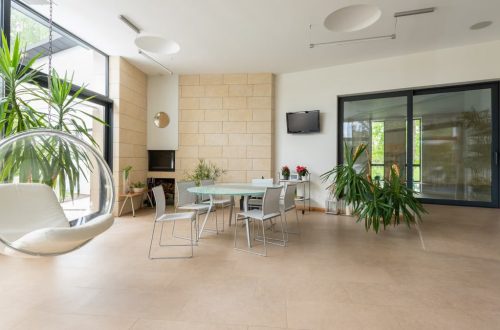 Modern large apartment with contemporary interior and table with chairs in bright daylight